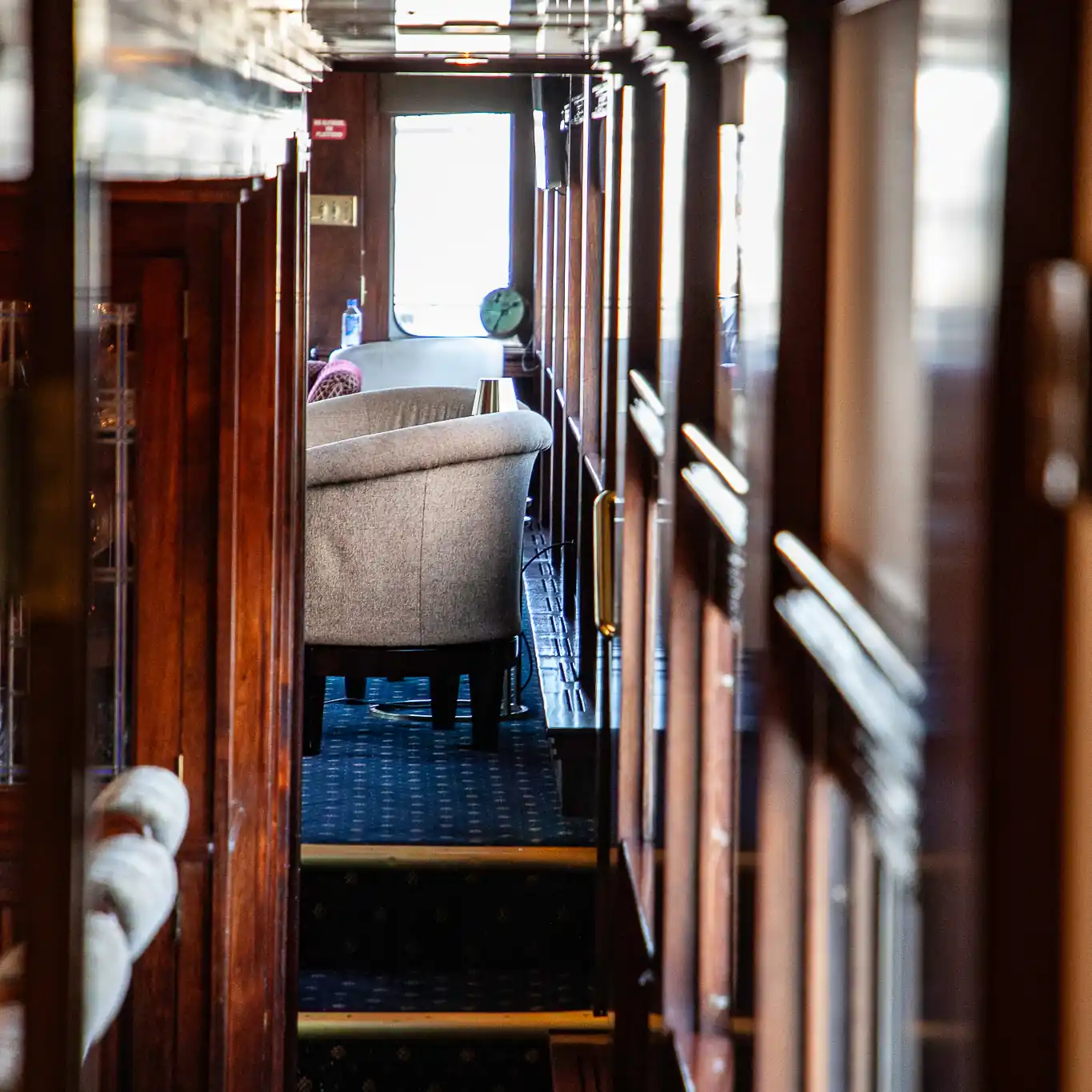 A photograph of a hallway inside of a private railcar with a lounge